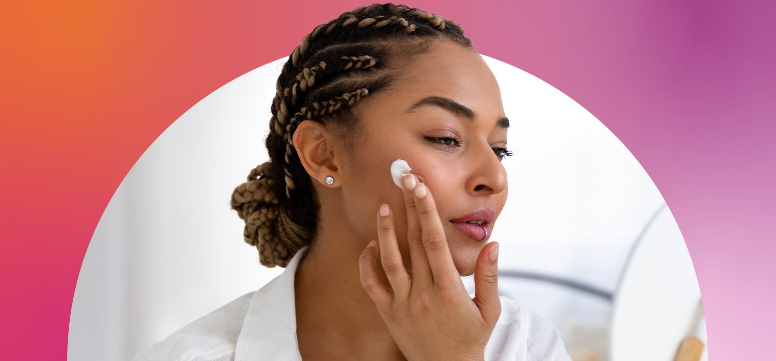  mulher aplicando creme no rosto com cabelo trançado