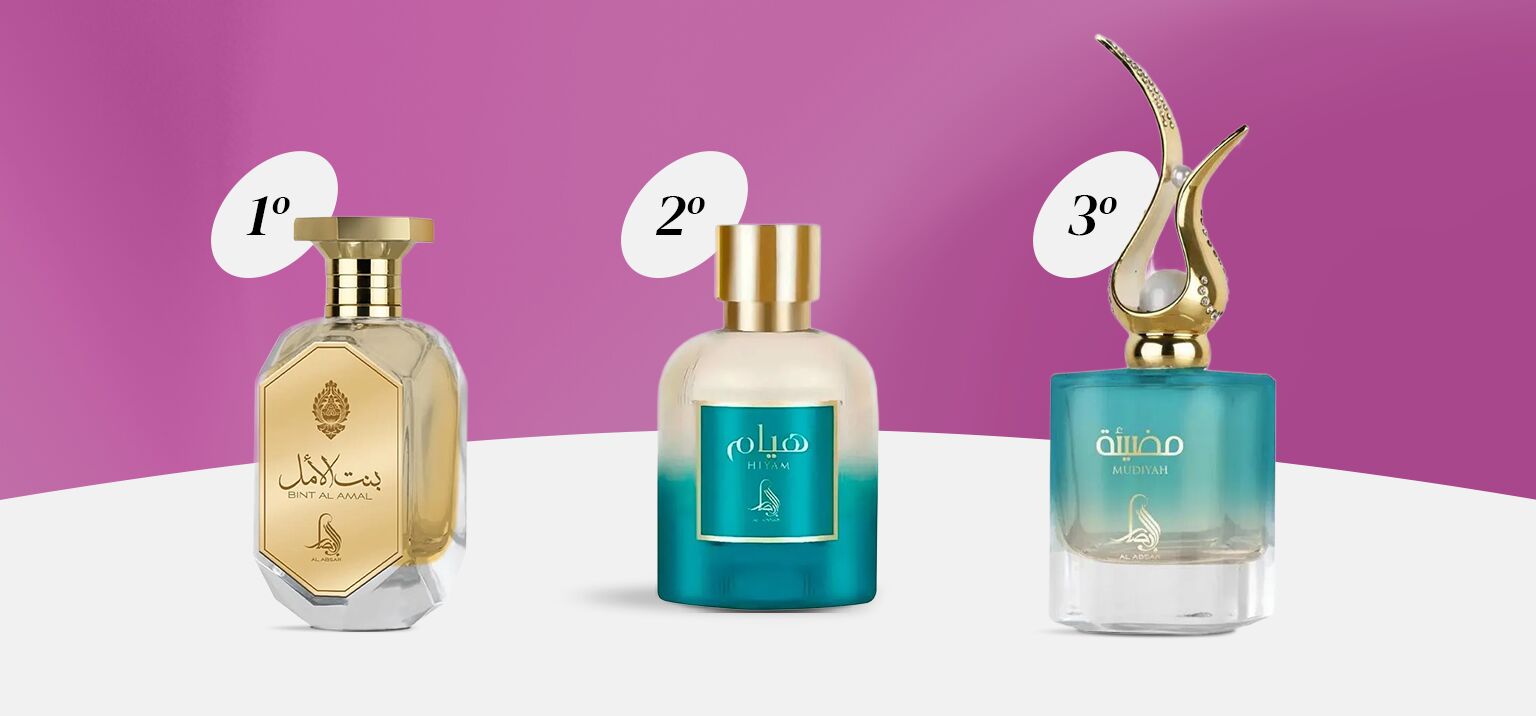 Quatro frascos de perfumes em fundo rosa.