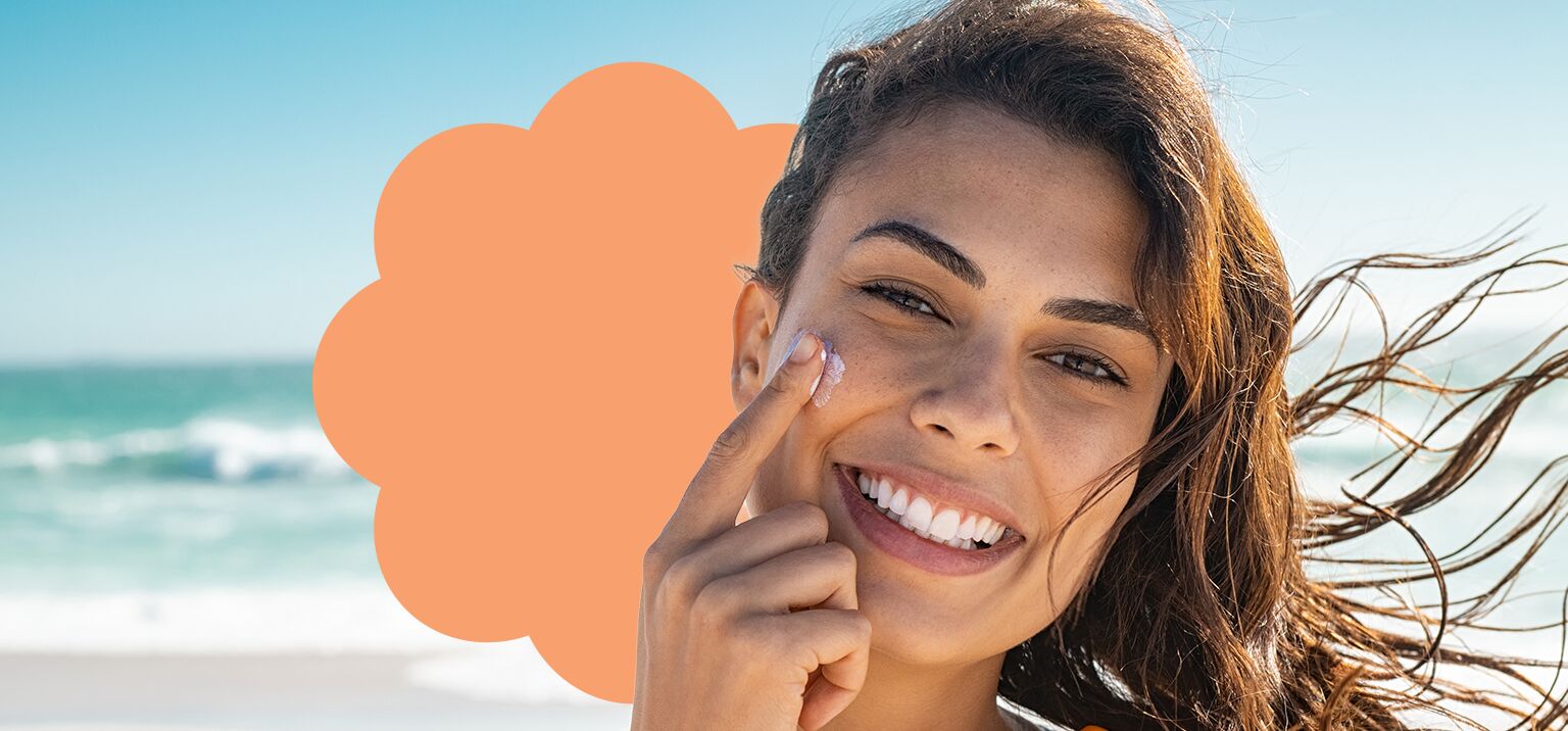 Mulher aplicando creme facial na praia