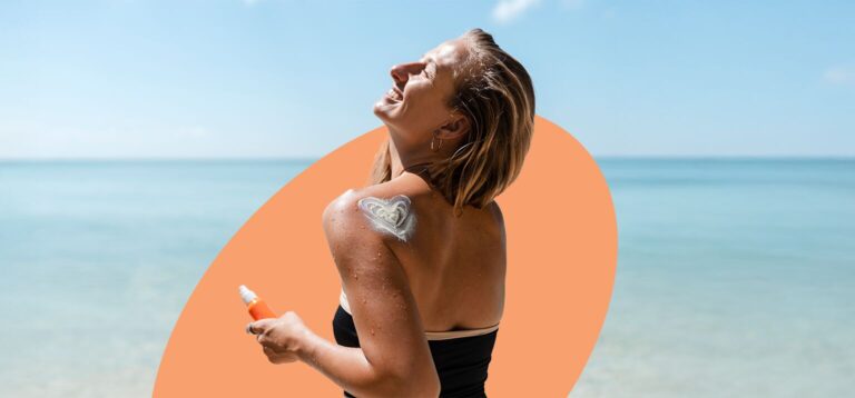 Mulher aplicando protetor solar na praia