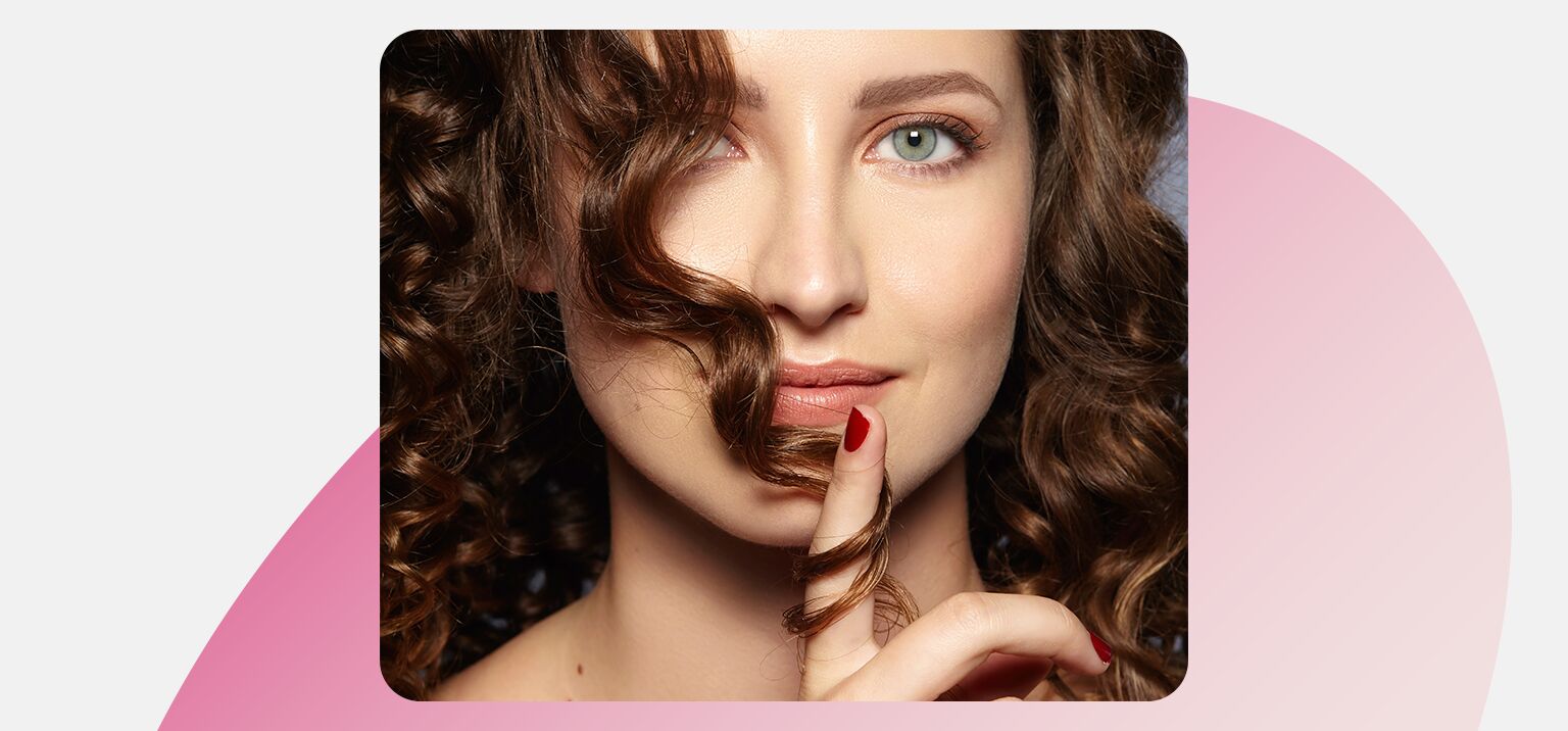 Mulher com cabelo cacheado fazendo gesto de silêncio.