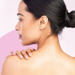 Mulher com cabelo preso, mostrando a pele do ombro