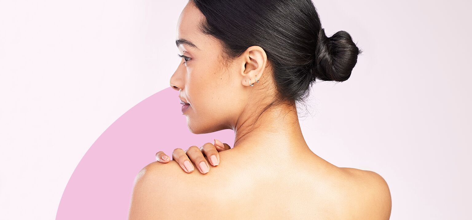 Mulher com cabelo preso, mostrando a pele do ombro